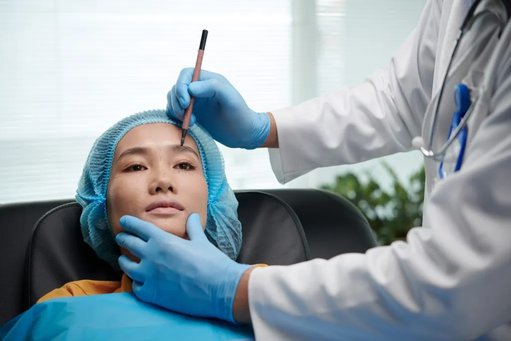 Plastic surgeon marking patient before facelift