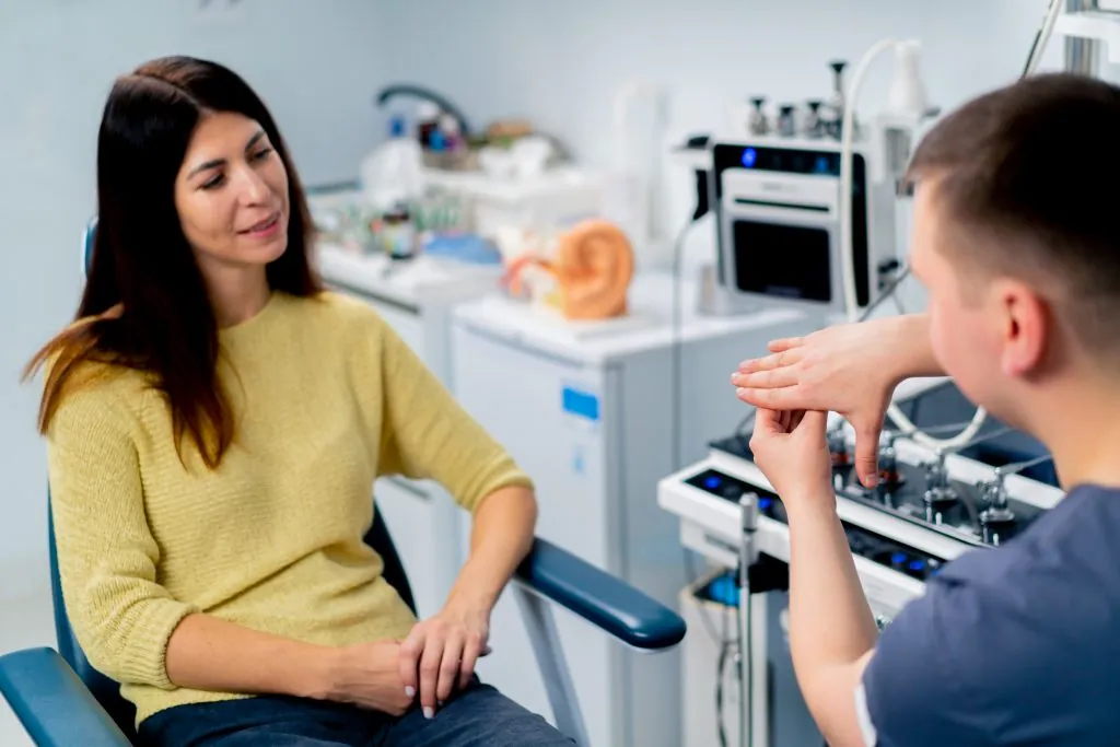 the ENT doctor consults the patient in the office of the clinic and tells about the possible consequences of operation